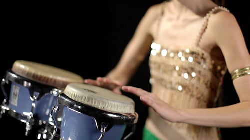 Woman Playing Conga Drums in Dark Studio
