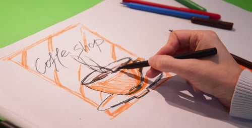 Hand sketching a coffee shop logo on paper