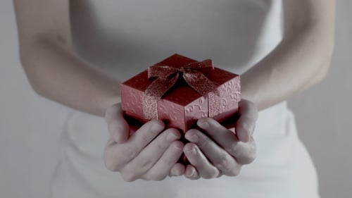 Woman Holding Small Red Gift Box with Bow