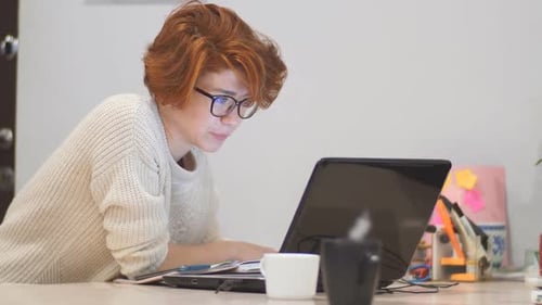 Young Adult Working on Laptop Computer in Office