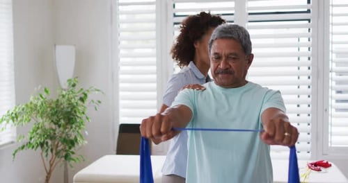 Senior Man Stretching Resistance Band with Medical Assistance