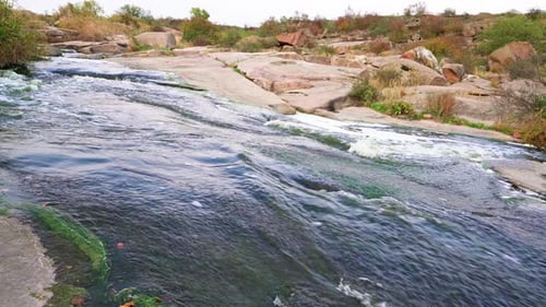 A Small Shining Stream Flows Among Smooth Wet and Dark Stones