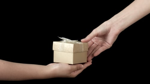 Child Receives a Small Birthday Gift from Adult