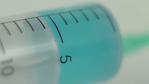 Syringe Filling with Blue Liquid in Close Up