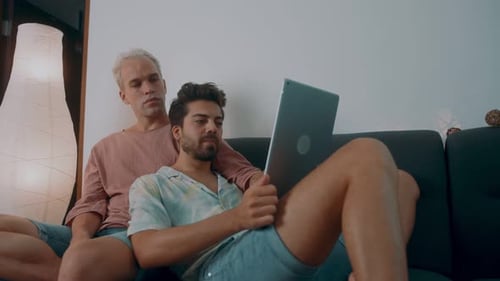 Gay Couple Relaxing at Home with Tablet