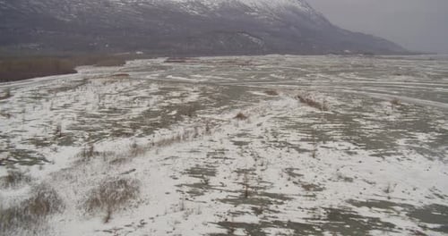 Lufthubschrauber weit geschossen, kippen Sie an der alaskischen Bergkette vorbei, über das Tal, um den verschneiten Hang