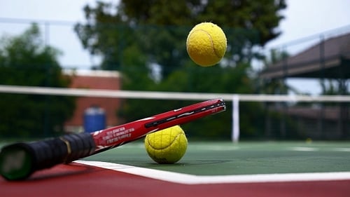 Tennis Balls and Racket on the Court