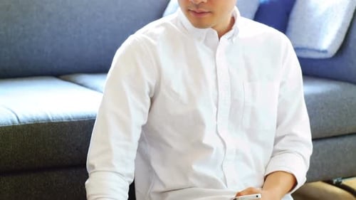 Young Adult Working on Laptop and Holding Phone