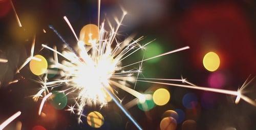 Sparkler Ignites with Christmas Bokeh Background
