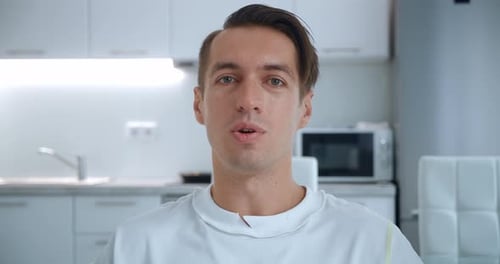 Webcam View of Smiling Young Man Making Video Call While Sitting in Living Room