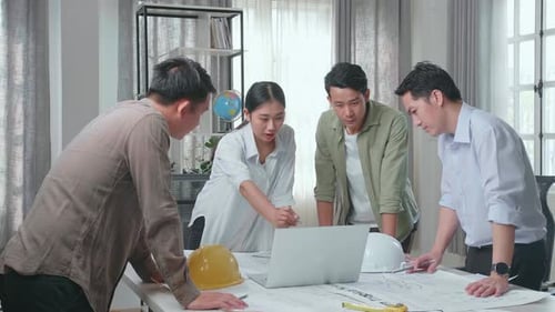 Group Of Asian Engineers Using A Laptop For Working At The Office