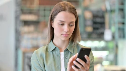 Woman Using Smartphone in Cafe