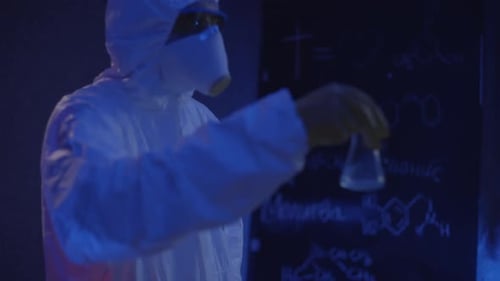 L'homme de chimie aux masques travaille avec les liquides