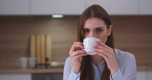 Woman Drinking Coffee in Her Modern Kitchen