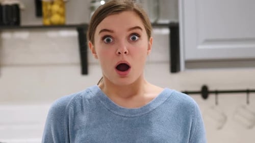 Woman Expressing Surprise and Shock in Kitchen
