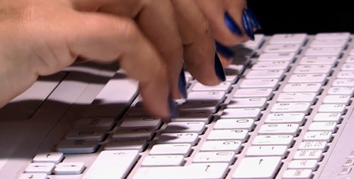 Woman Typing on Keyboard with Blue Nails