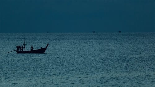 Silhouette of Fishing Boat at Sea at Night