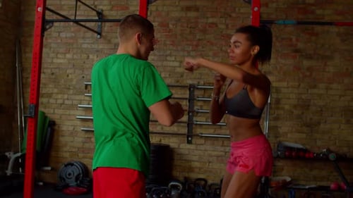Motivated Sporty Fit African American Female Boxer Training Hook with Coach