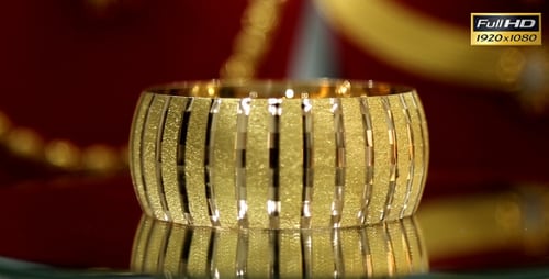 Sparkly Gold Bangle on Reflective Surface