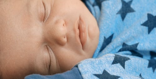 Infant Sleeping Peacefully in Blue Star Pajamas