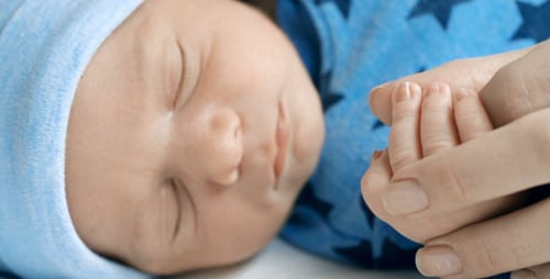 Precious Newborn Baby Hand Held by Caring Adult