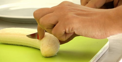 Cutting a Banana on a Green Cutting Board