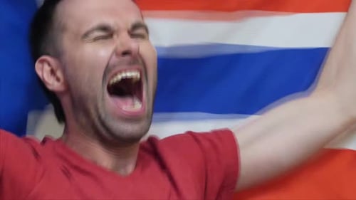 Man Cheering in Front of a Flag