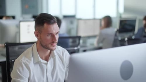 Portrait of Young Entrepreneur in Open Space Office Working on Decktop Computer