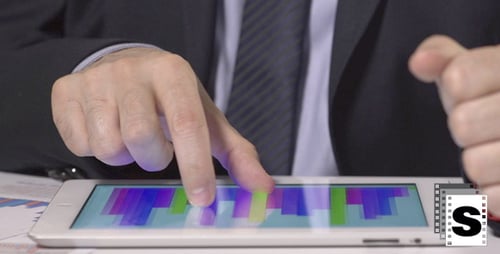 Executive Reviews Financial Data on Tablet at Workplace