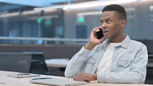 African Man Talking on Smartphone in Office