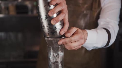 Bartender Preparing Cocktail with Strainer and Shaker