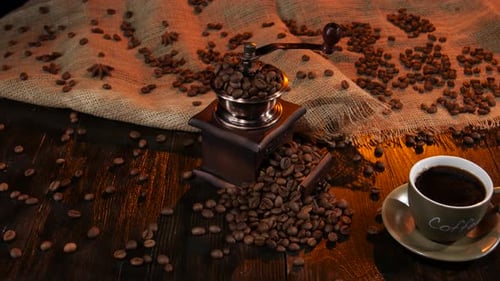 Tasse Schwarzer heißer Kaffee und Bohnen auf dem Tisch verstreut