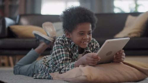 Boy Enjoys Tablet on Floor at Home