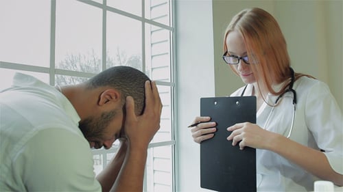 Doctor Consults With Patient in Clinical Setting