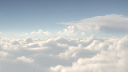 Beautiful Aerial View Flying Through Fluffy White Clouds in Blue Sky