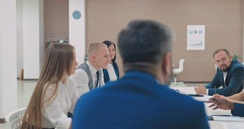 Group of Young People Holds a Business Meeting in a Modern Coworking Center a Bright Room
