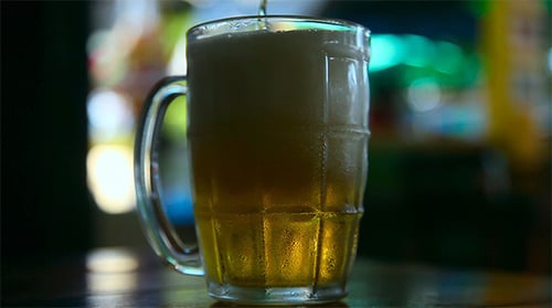 Beer Being Poured Into Clear Glass Mug