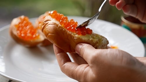 Preparing Caviar Snack on Buttery Bread Slice