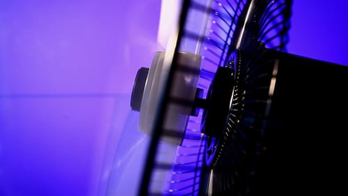 Close up of a Fan Spinning with Purple Background
