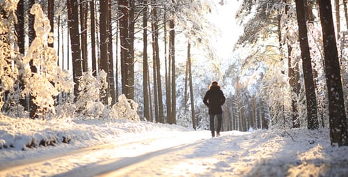 Man Walking in Winter Forest