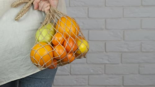 Compra de frutas ecológicas con una bolsa de red