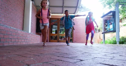Crianças sorridentes correndo no corredor da escola