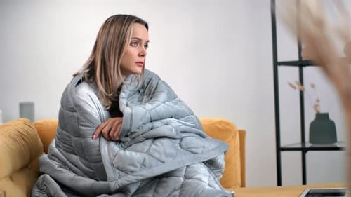 Mulher infeliz: cobertor embrulhado em frio, apatia, avitaminose, depressão sazonal