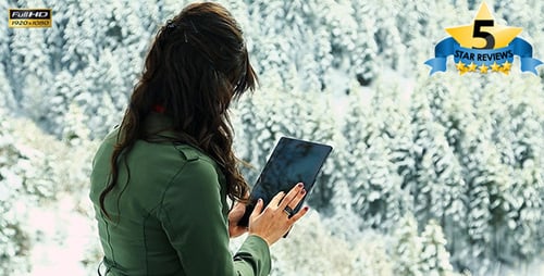 Woman Uses Tablet in a Snowy Winter Landscape
