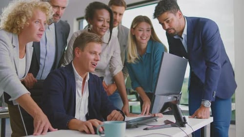 Team Cheering at Computer in Bright Office