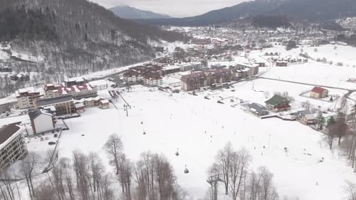 Aerial view of the ski resort with snowy mountain slopes and winter trees.