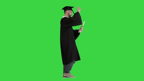 Graduate Student Walking and Tossing Up His Hat on a Green Screen Chroma Key