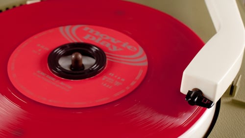 Red Vinyl Record Spins on Player Close Up