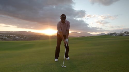 Man Playing Golf at Sunset on Rural Course
