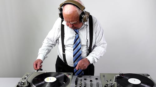 Senior Man Actively DJing with Turntables